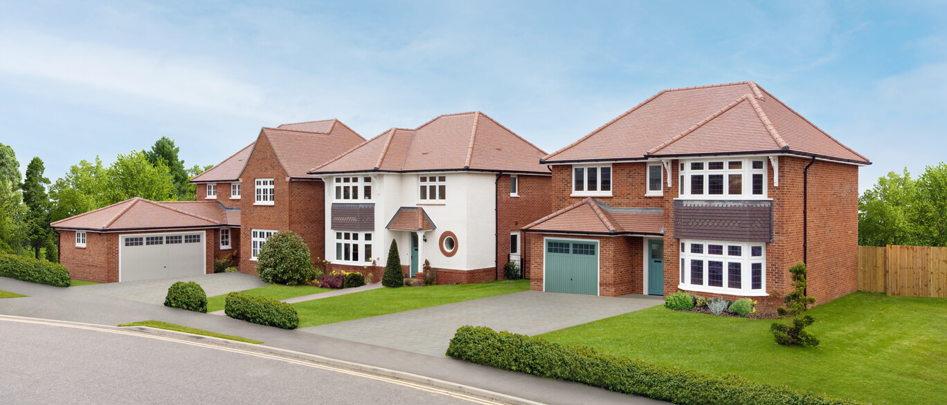 Modern detached houses with brick and white exteriors, bay windows, and well-maintained gardens in a suburban neighbourhood.