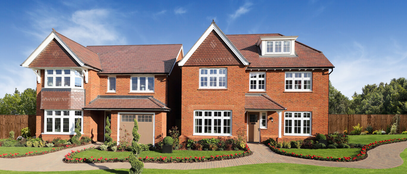 A large red-brick modern house with white-framed windows, front garden, and a driveway, under a blue sky with some clouds, part of Orchids Place development.