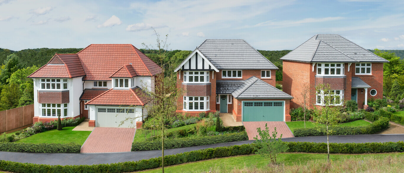 Three modern detached houses with colourful roofs, surrounded by greenery and a curved driveway, on a sunny day in the countryside at Mandeville Crescent.