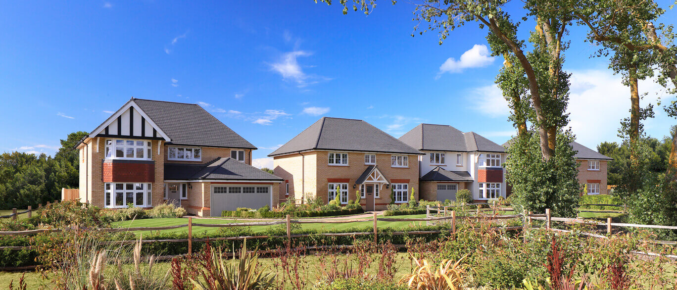 Modern detached houses with landscaped gardens under a blue sky at Redrow Millview Park in the UK at Millview Park.