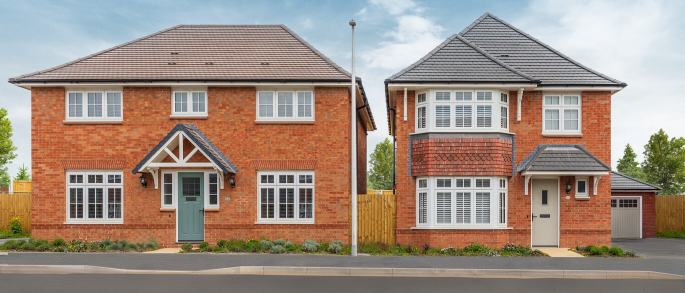 Two modern red brick houses with grey tiled roofs, white framed windows, and small front gardens, separated by a wooden fence at Dovecote Grange.