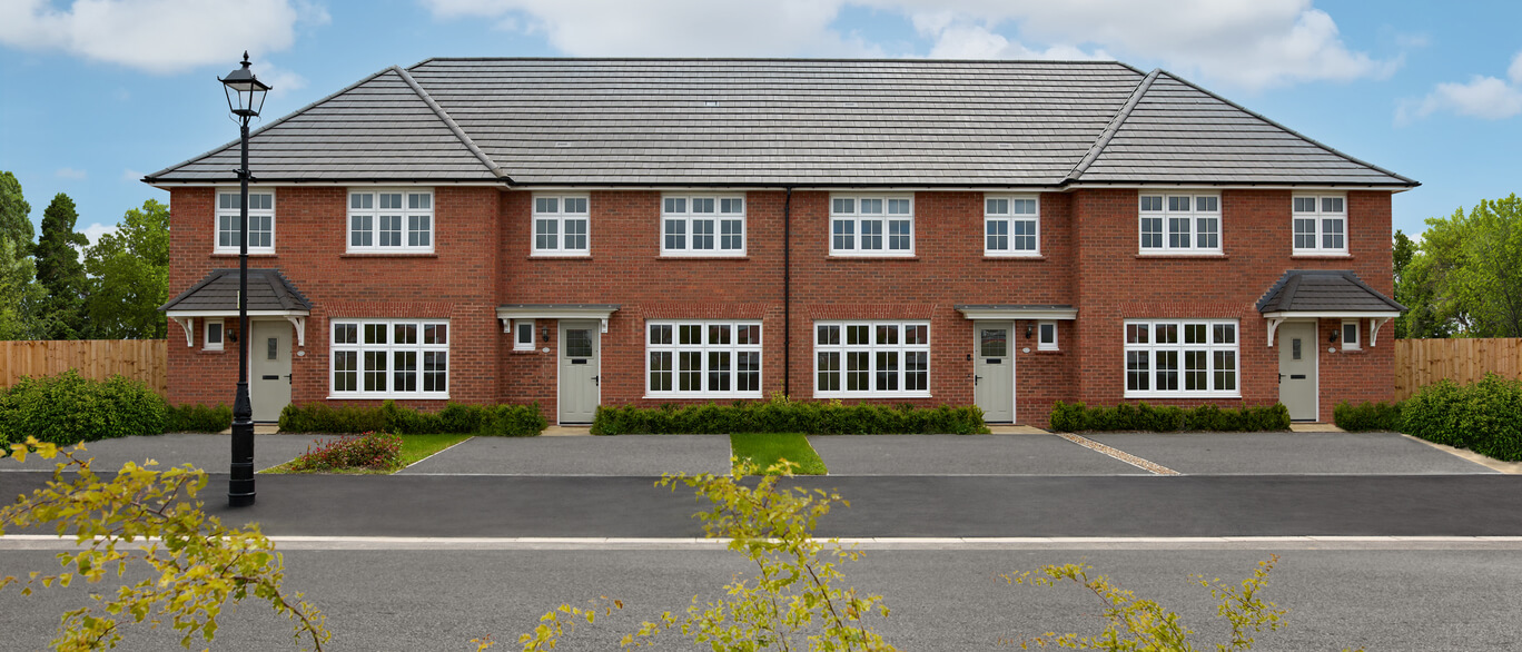 A row of modern red-brick terraced houses with white framed windows and grey tiled roofs under a blue sky at Anson Meadows.