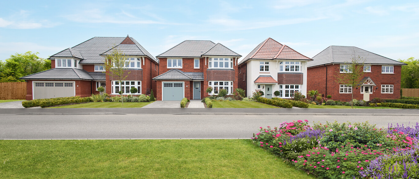 Row of four modern red-brick houses with grey roofs, driveways, and front gardens, facing a road with flower beds and grassy verge at Sycamore Green, Ledsham Garden Village.