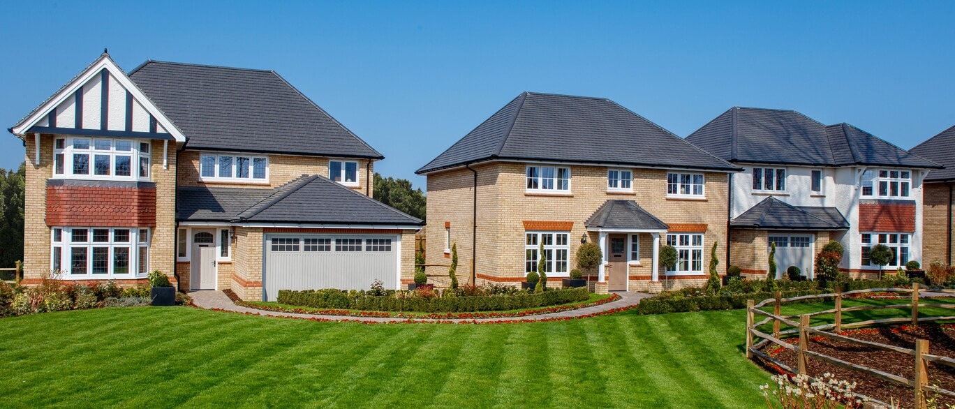 Impressive modern detached houses with well-maintained gardens and a bright blue sky at St David's Park.