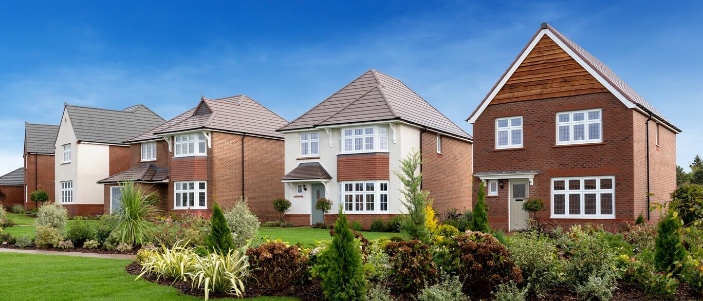 Brick houses in Hampden Meadows, surronded by a beautiful garden with flowers under a blue sky at Hampden Meadows.