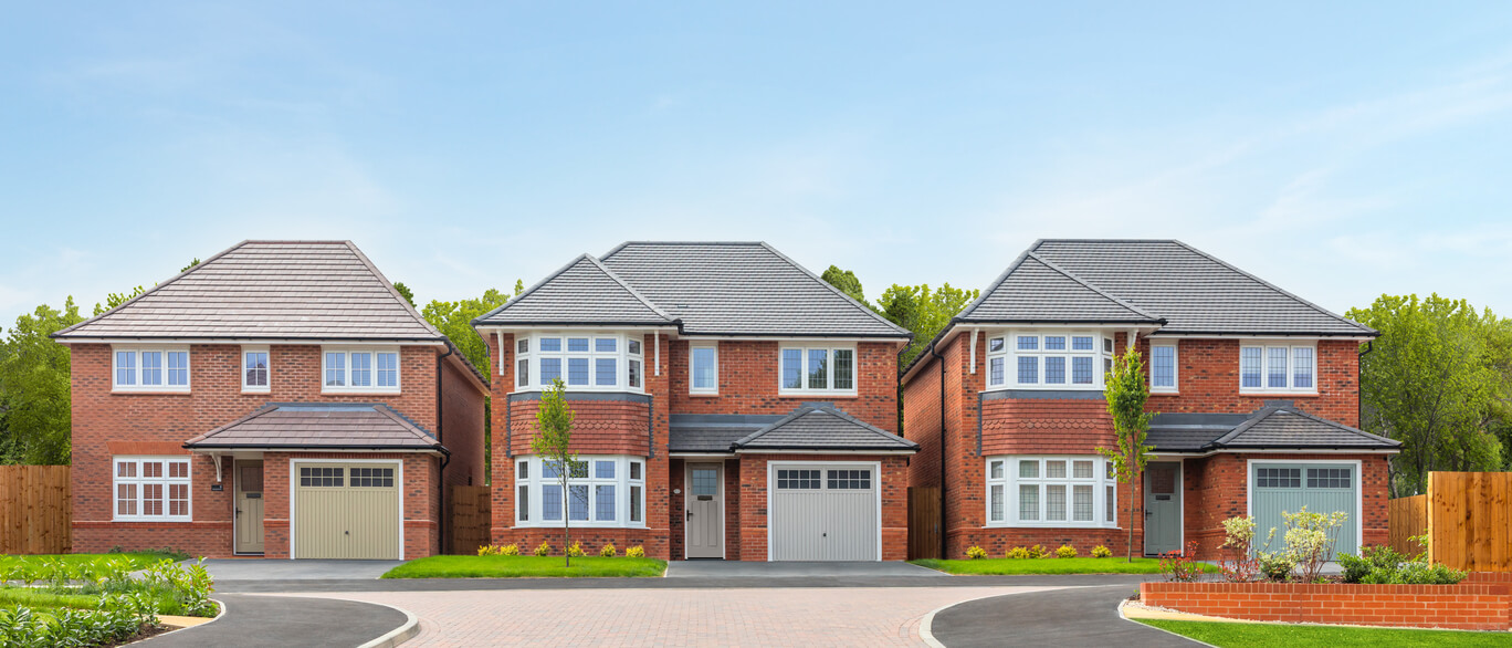 Three modern detached red-brick houses with grey tiled roofs and white window frames in a suburban neighbourhood under a blue sky at Templars Park.