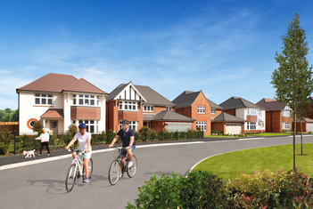 2 people riding bikes past Redrow development