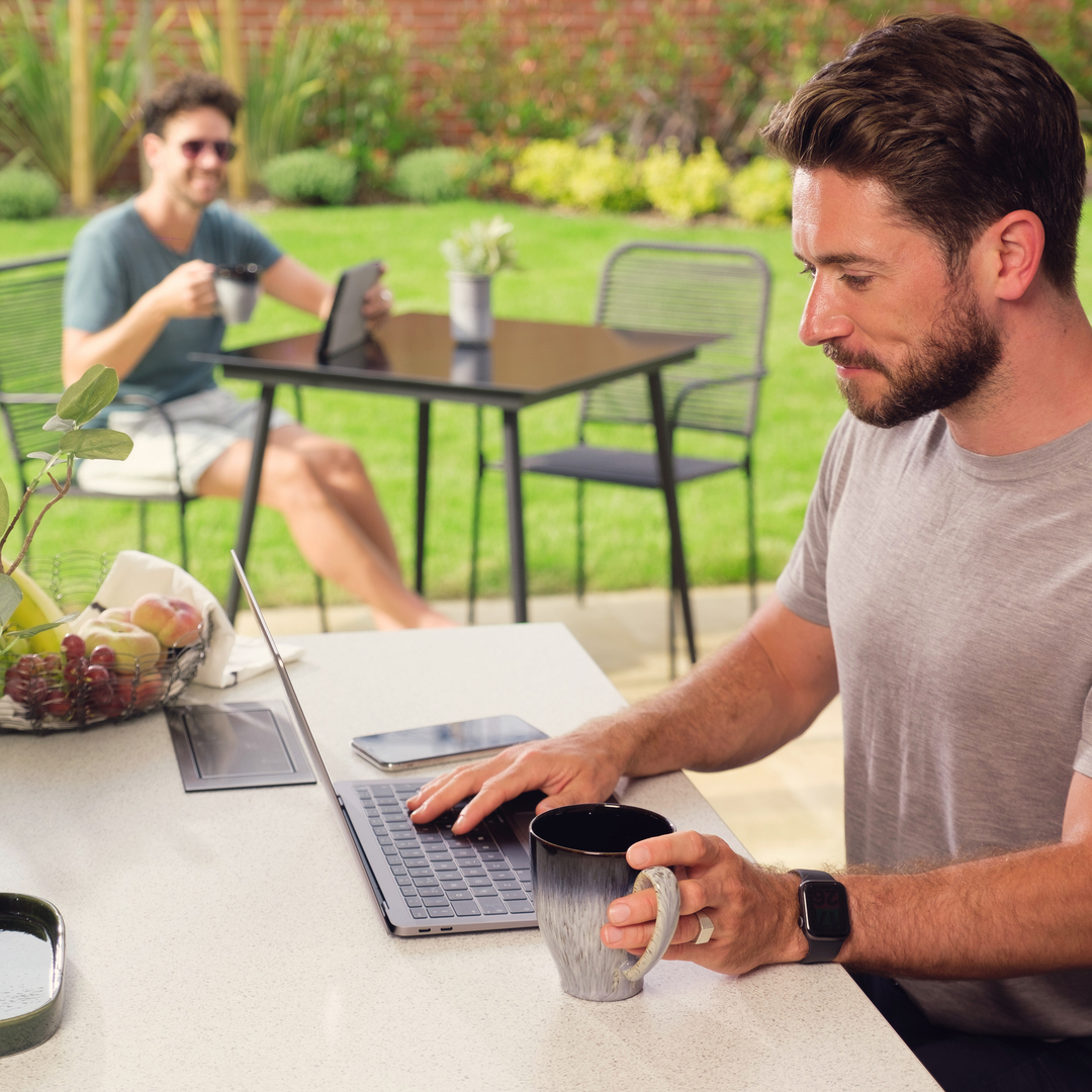 A man on his laptop next to his new home garden
