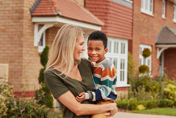 Mother holding her son outside Redrow Heritage home
