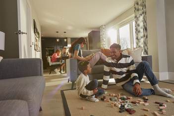 Family relaxing in open plan kitchen family area