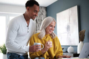 Happy couple looking at laptop