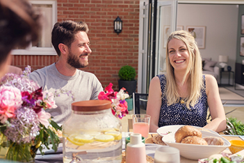 Couple alfresco dining in their new home garden 