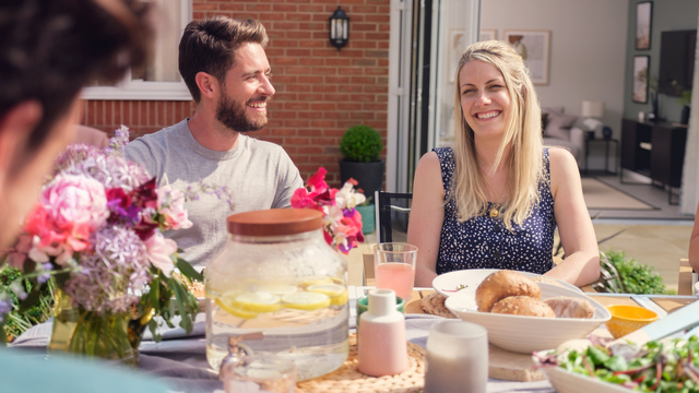 Couple alfresco dining in their new home garden