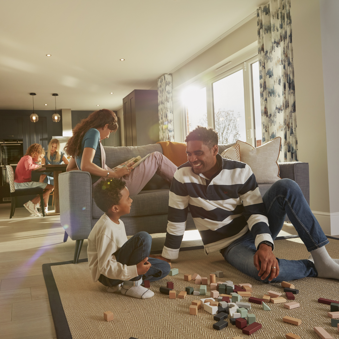 Family playing and relaxing in open plan Kitchen, dining, family room