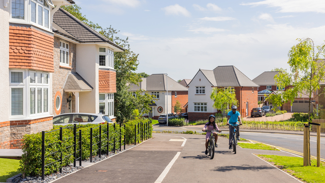 Father and daughter riding bikes through a Redrow Garden Village