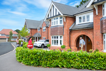 Friendly postman delivering post to new homeowner