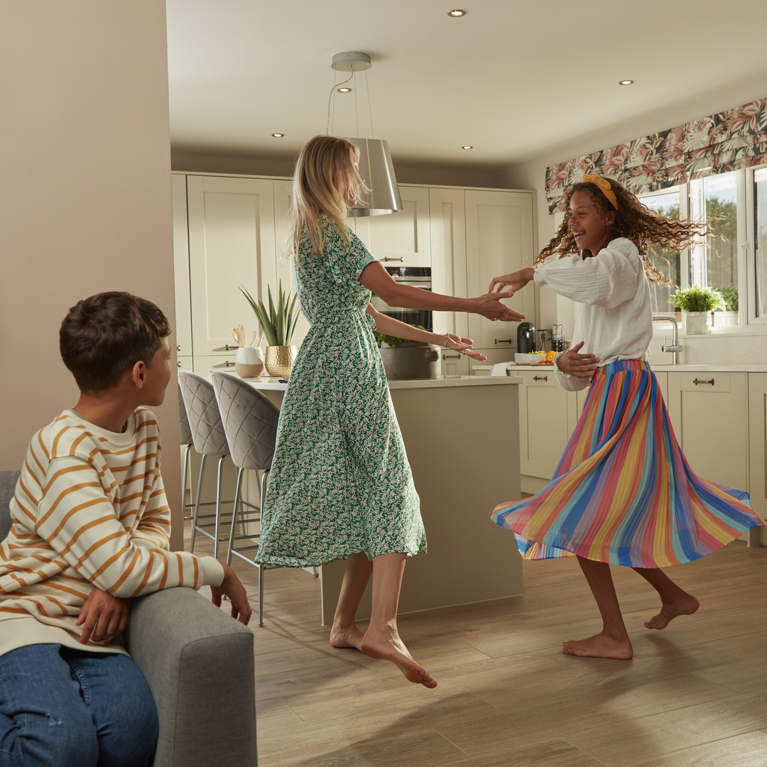 Two women dancing with no shoe in the kitchen