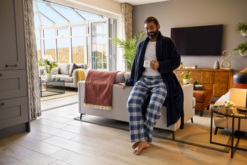 Man leaning on sofa bare footed with underfloor heating