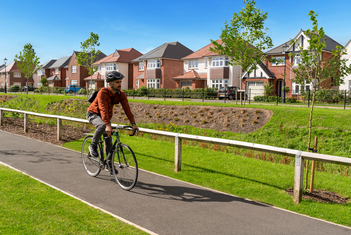 Man riding a bike through Woodford Garden Village
