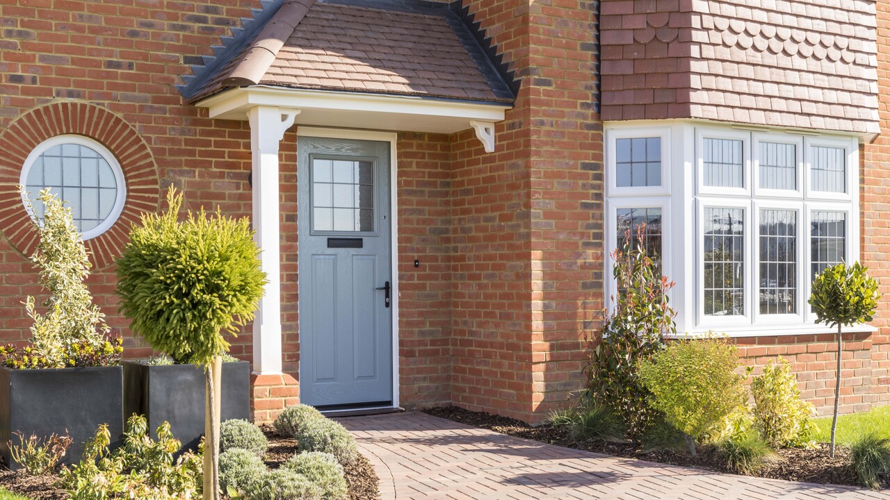 Exterior of the Leamington Lifestyle, with duck egg blue door and potted plants
