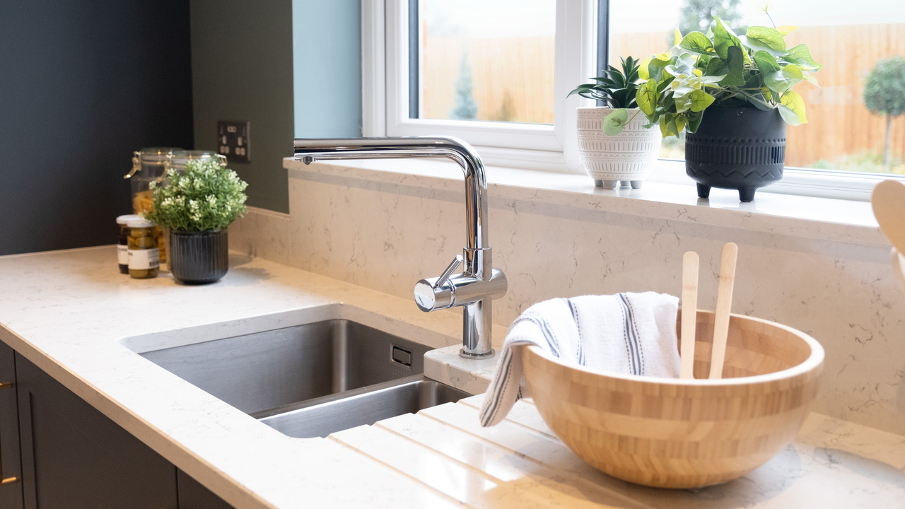 Large wooden bowl next to a kitchen sink