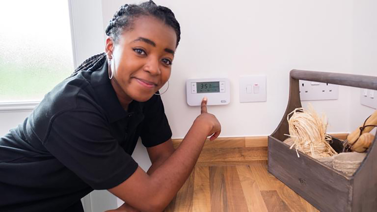 Woman pointing at thermostat