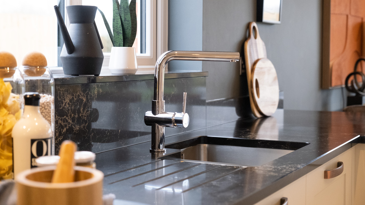 Kitchen sink with black worktop and chrome mixer tap