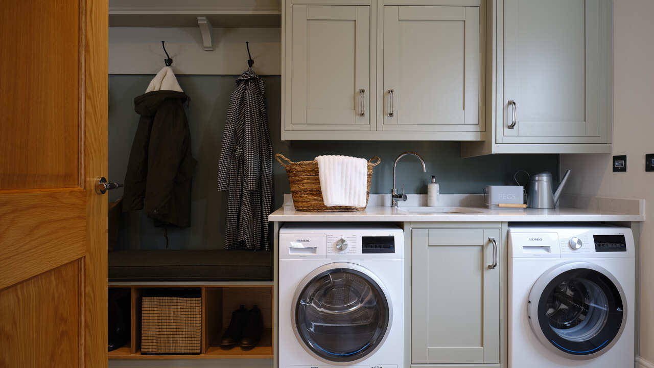 Utility room with coat hooks, built in units and washer and dryer