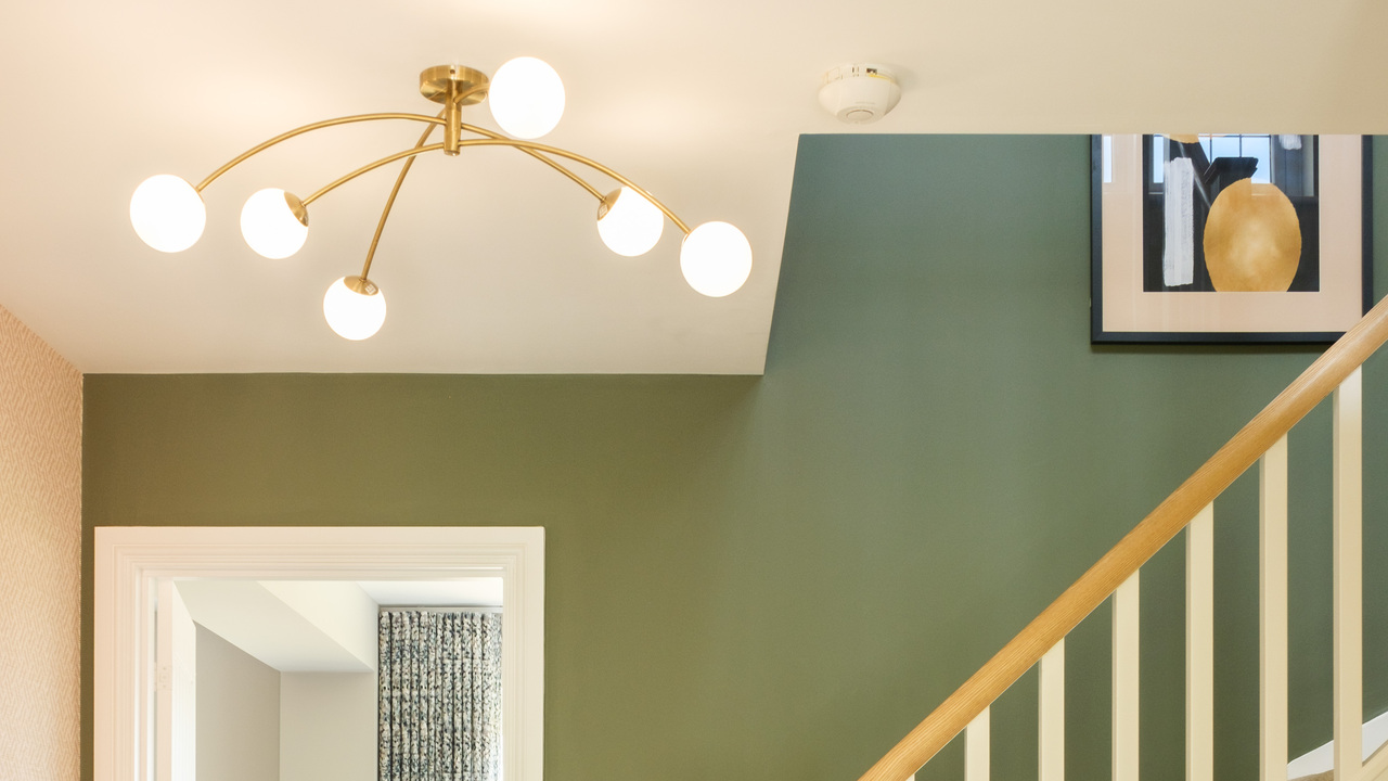 Gold ceiling light in a hallway with green walls