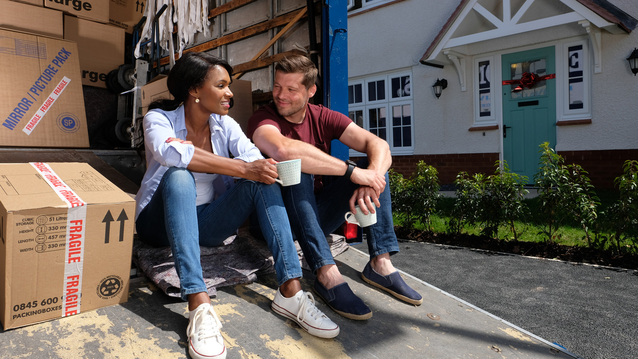 Couple sitting on their moving van and taking a break