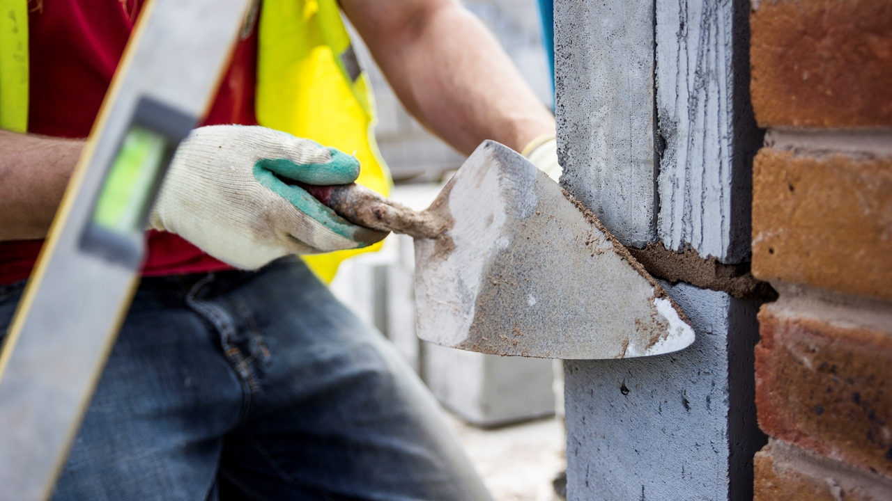 Builder using a trowel to get a smooth finish on some brickwork