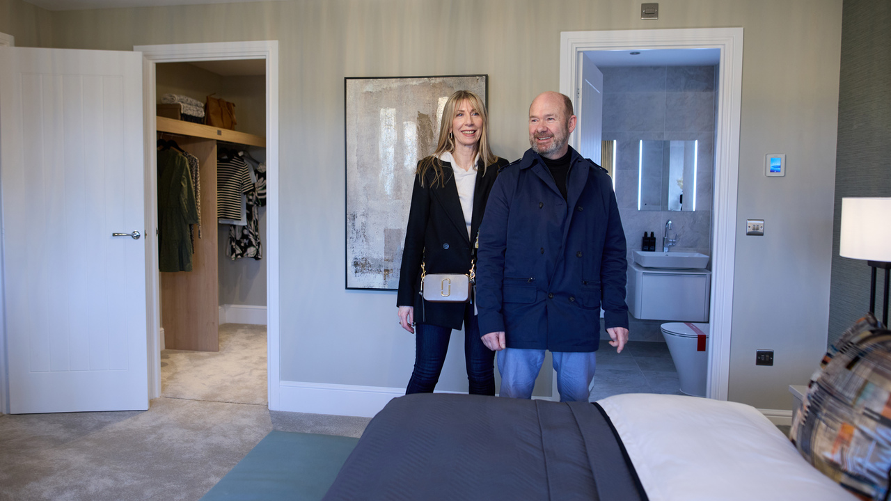 A couple looking at a bedroom in a Redrow show home
