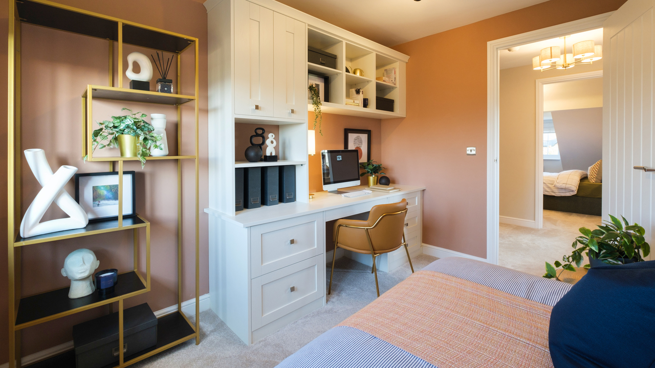 Beautifully styled home office with peach walls and built-in desk