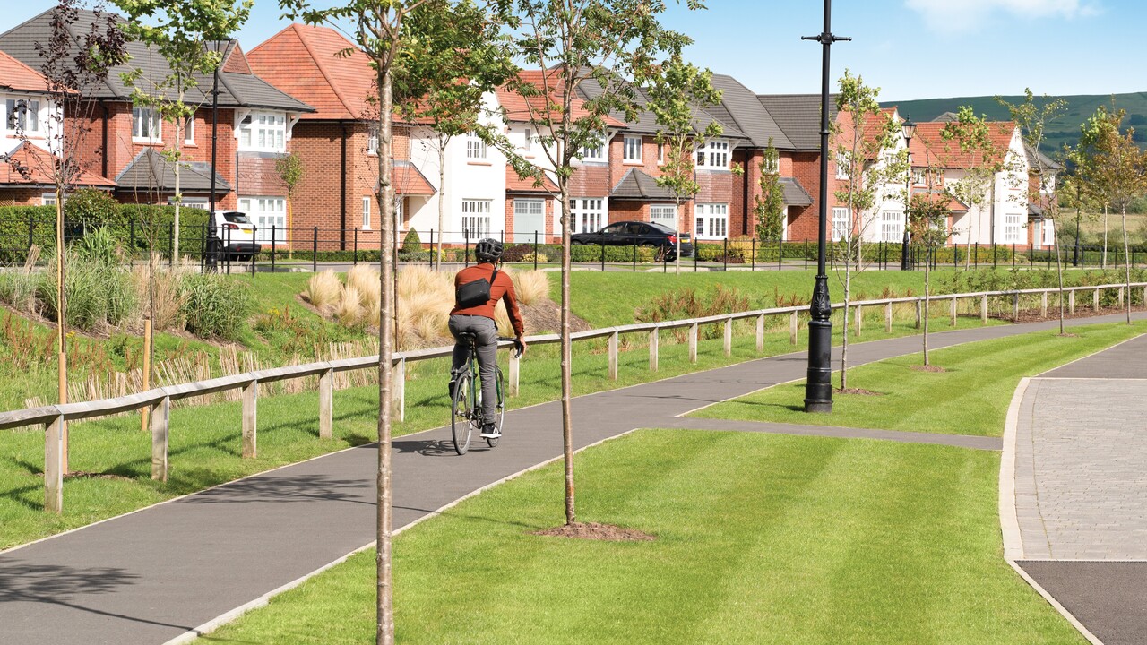 Man cycling down a cycle path at a Redrow development