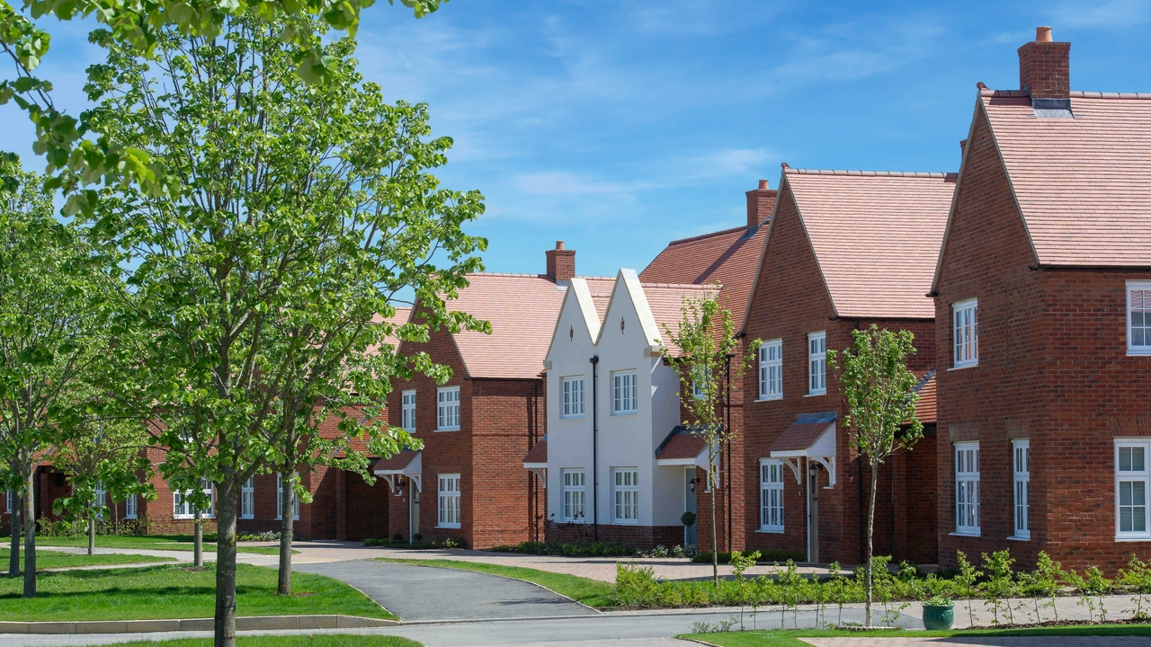 Redrow homes next to a tree-lined path