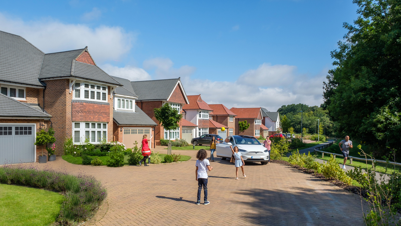 Children playing outdoors with Tesla in background
