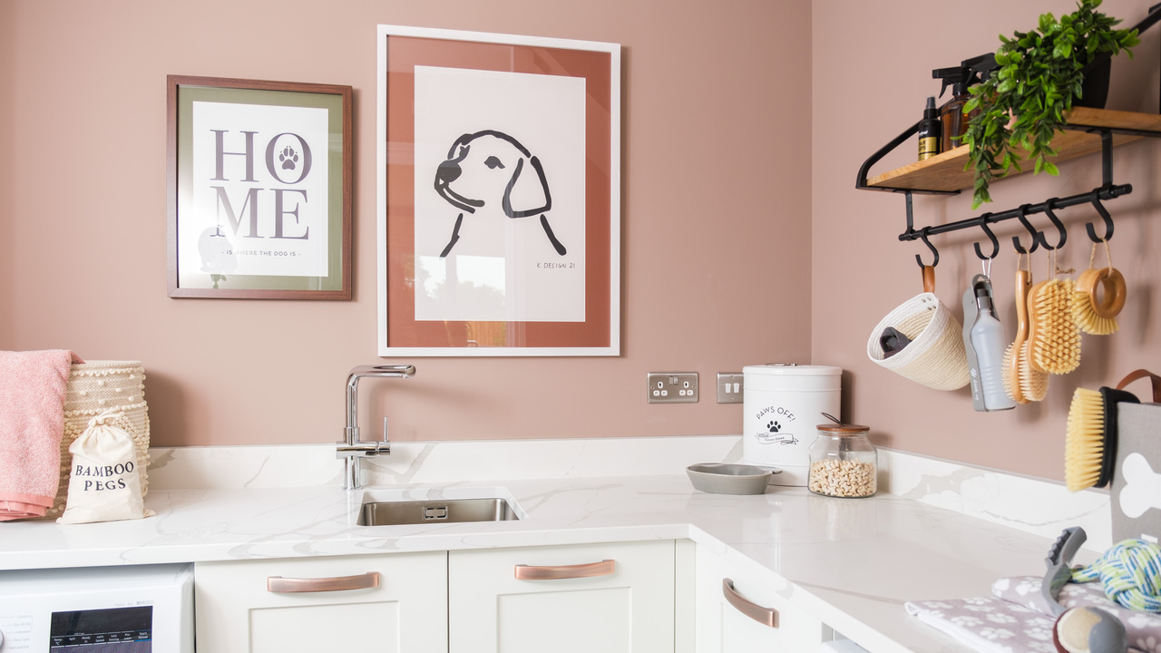 Utility room with pink walls and white units