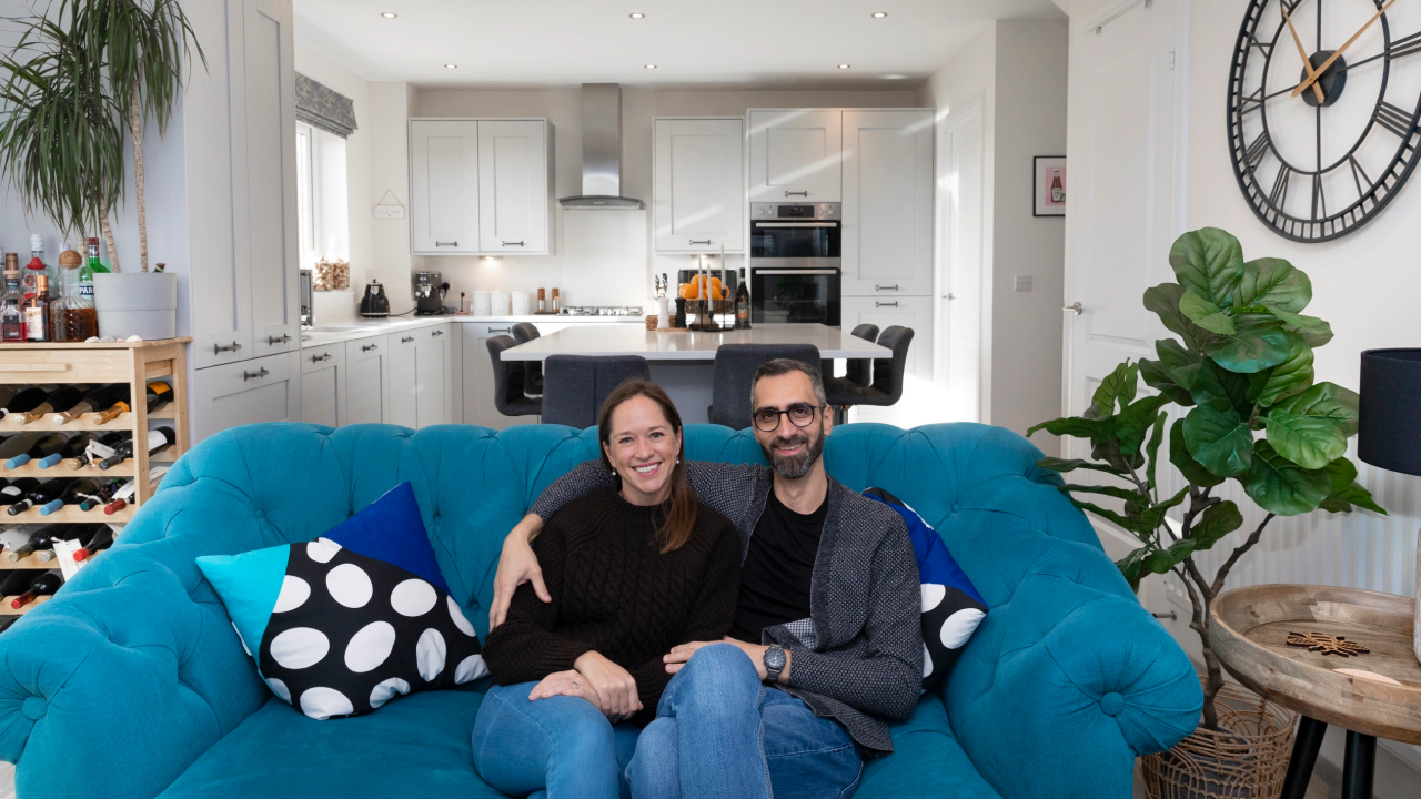 Nic and Sarah relax ion the couch in their new home