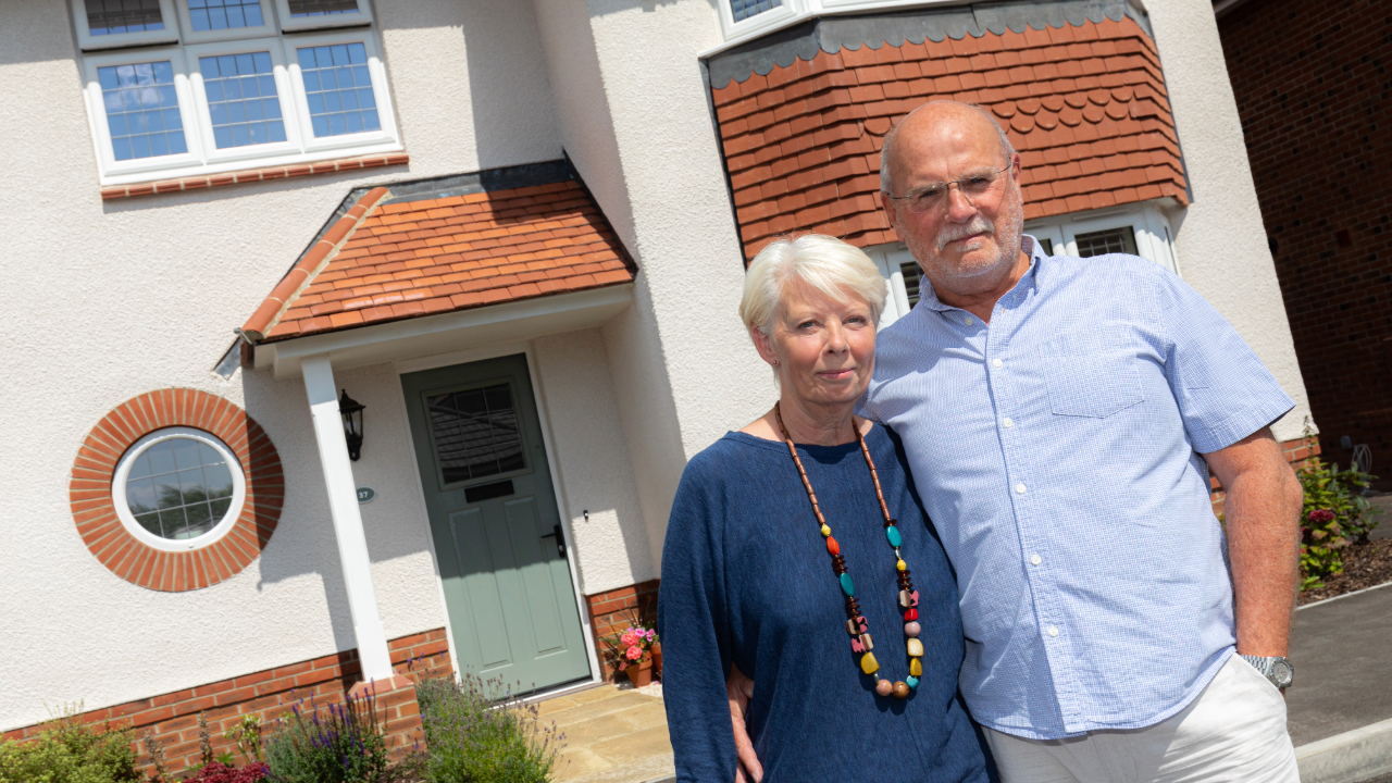 Couple standing outside their new home