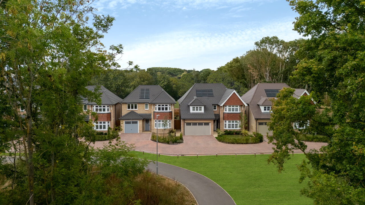 Four Redrow houses among a green space surrounded by beautiful trees