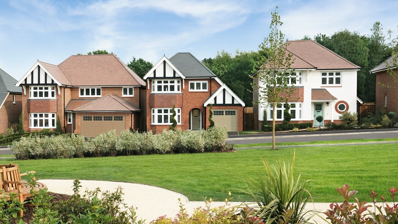 Three Heritage homes behind a green space with a bench