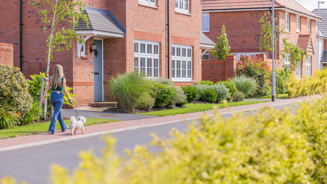 Woman walking her dog in a Garden Village