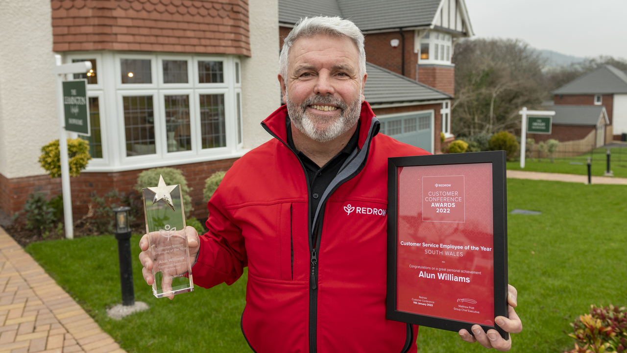 Redrow Customer Services Award winner Alun Williams proudly shows off his trophy and certificate