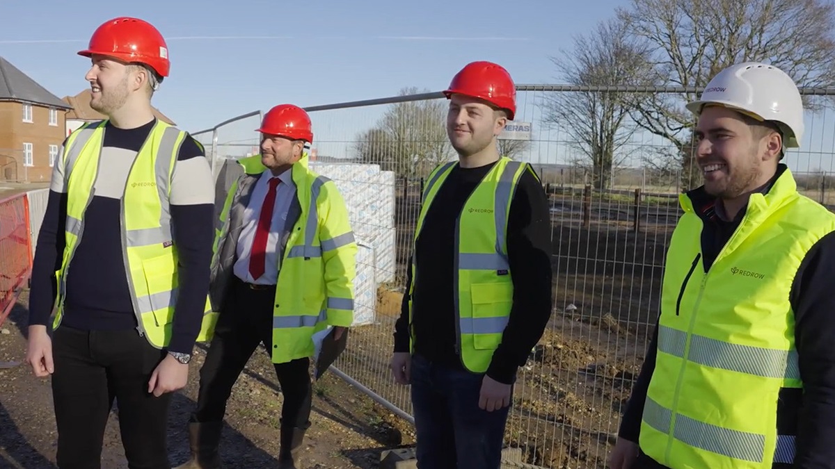 Four construction workers in hard hats and hi vis vests 