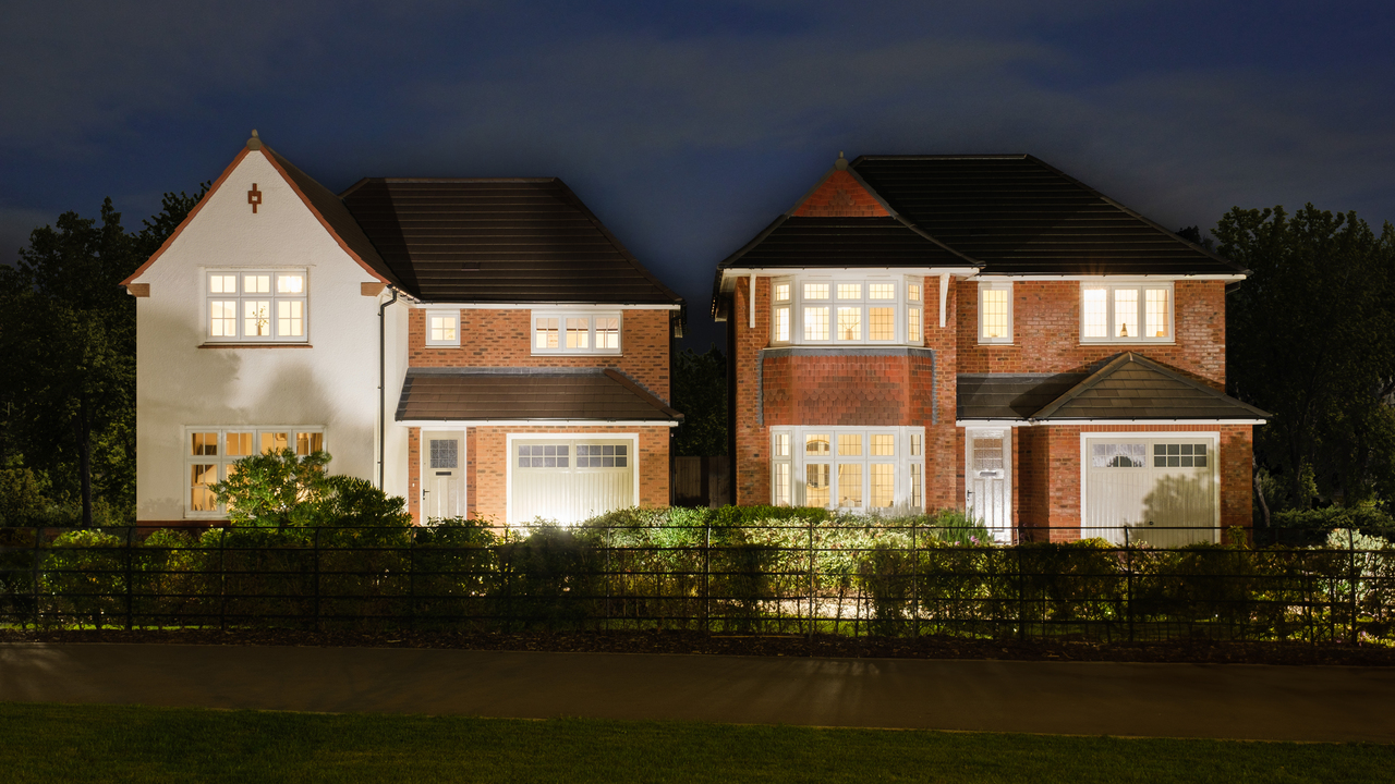Two Heritage homes at night, with glowing windows due to the lights being on