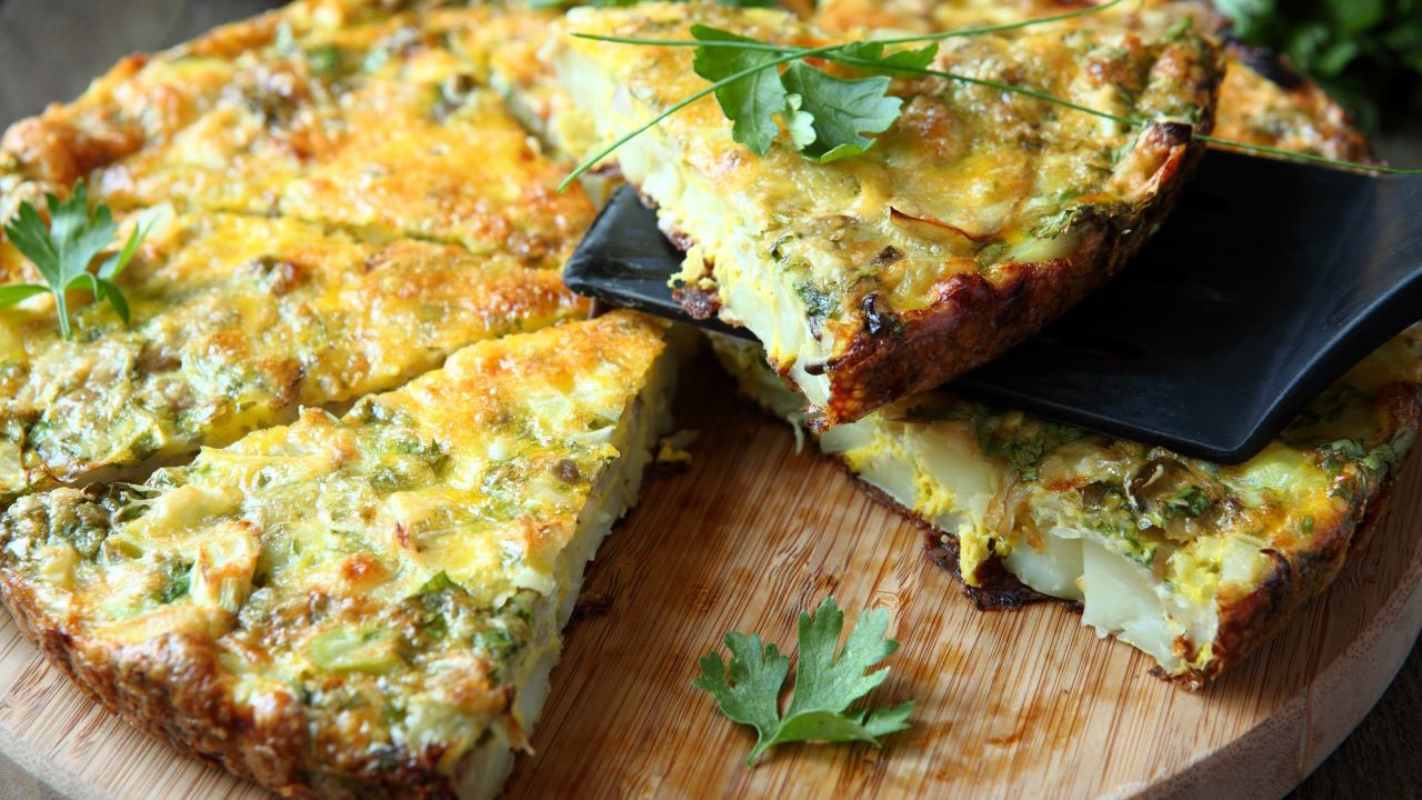 Frittata garnished with parsley on a wooden board 