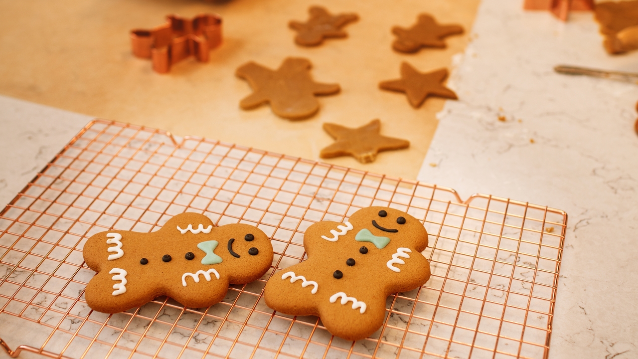 Two gingerbread men on a wire cooling rack