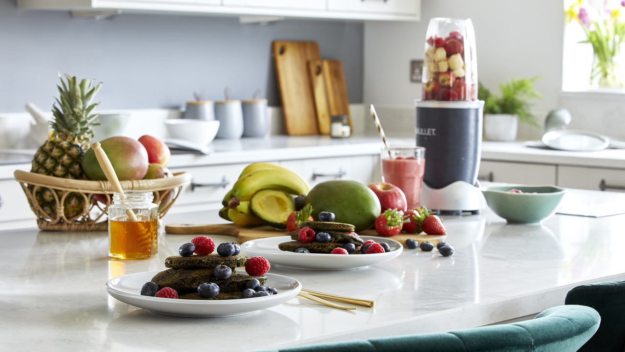 Kitchen island covered in fruits and healthy pancakes