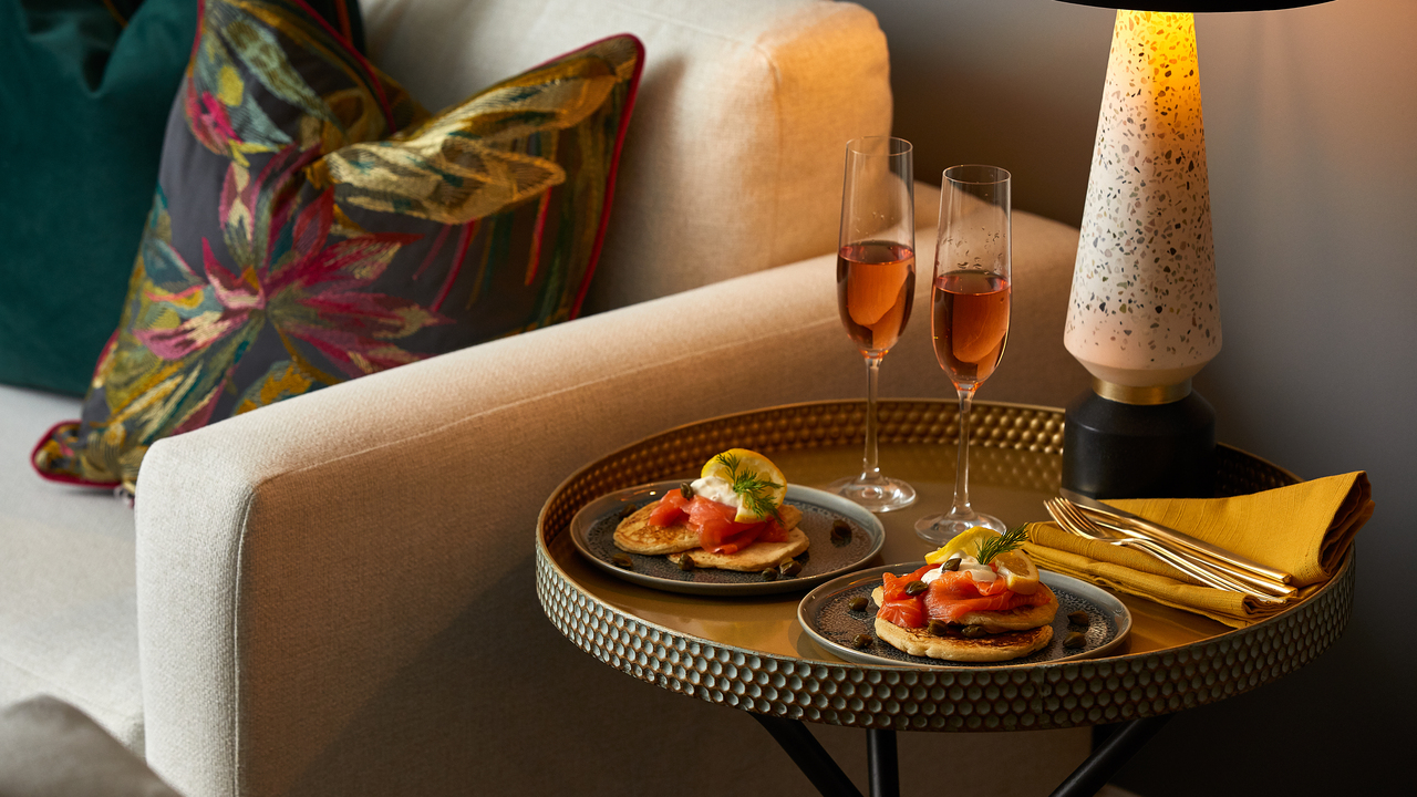Side table with two plates of savoury pancakes and two glasses of sparkling rose