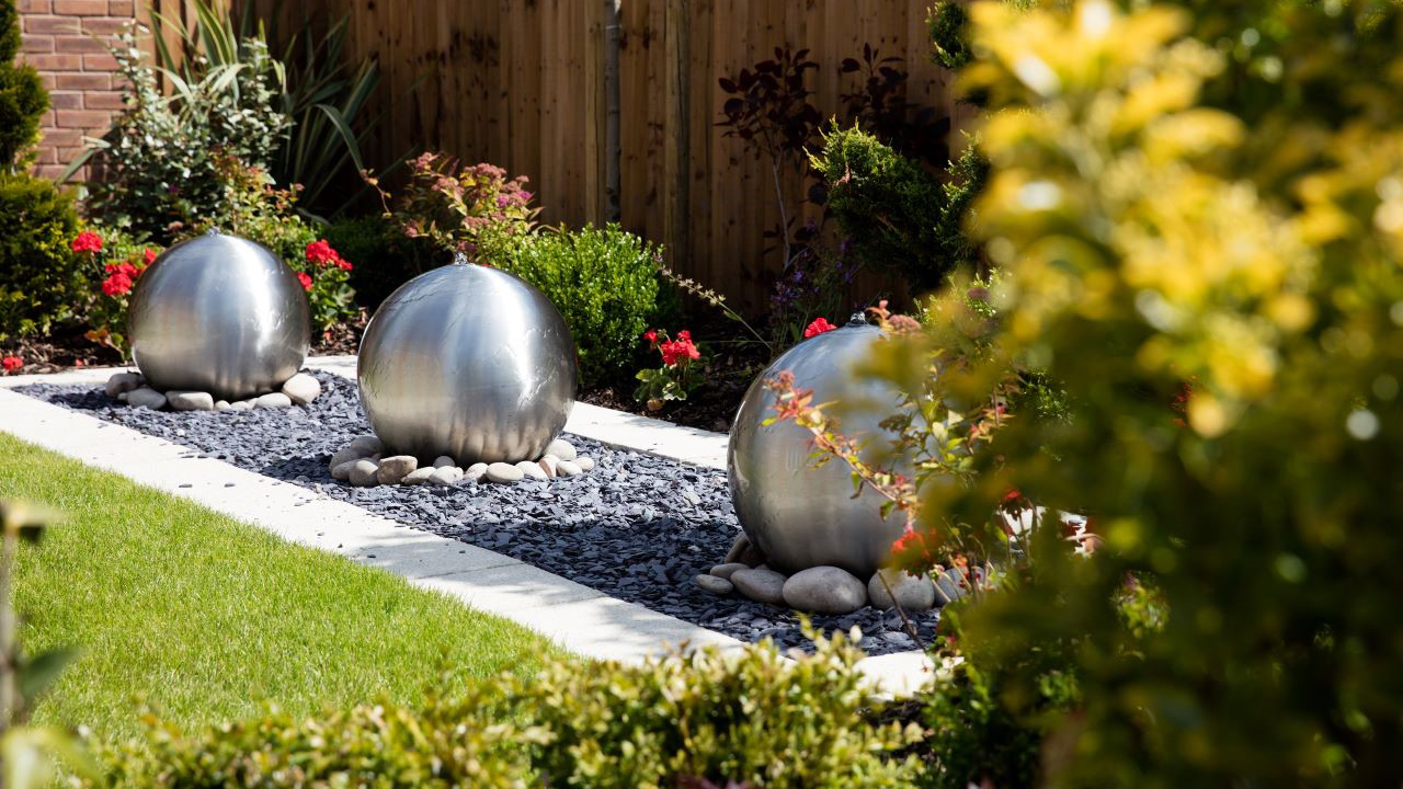 Three silver ball water features in a neat garden